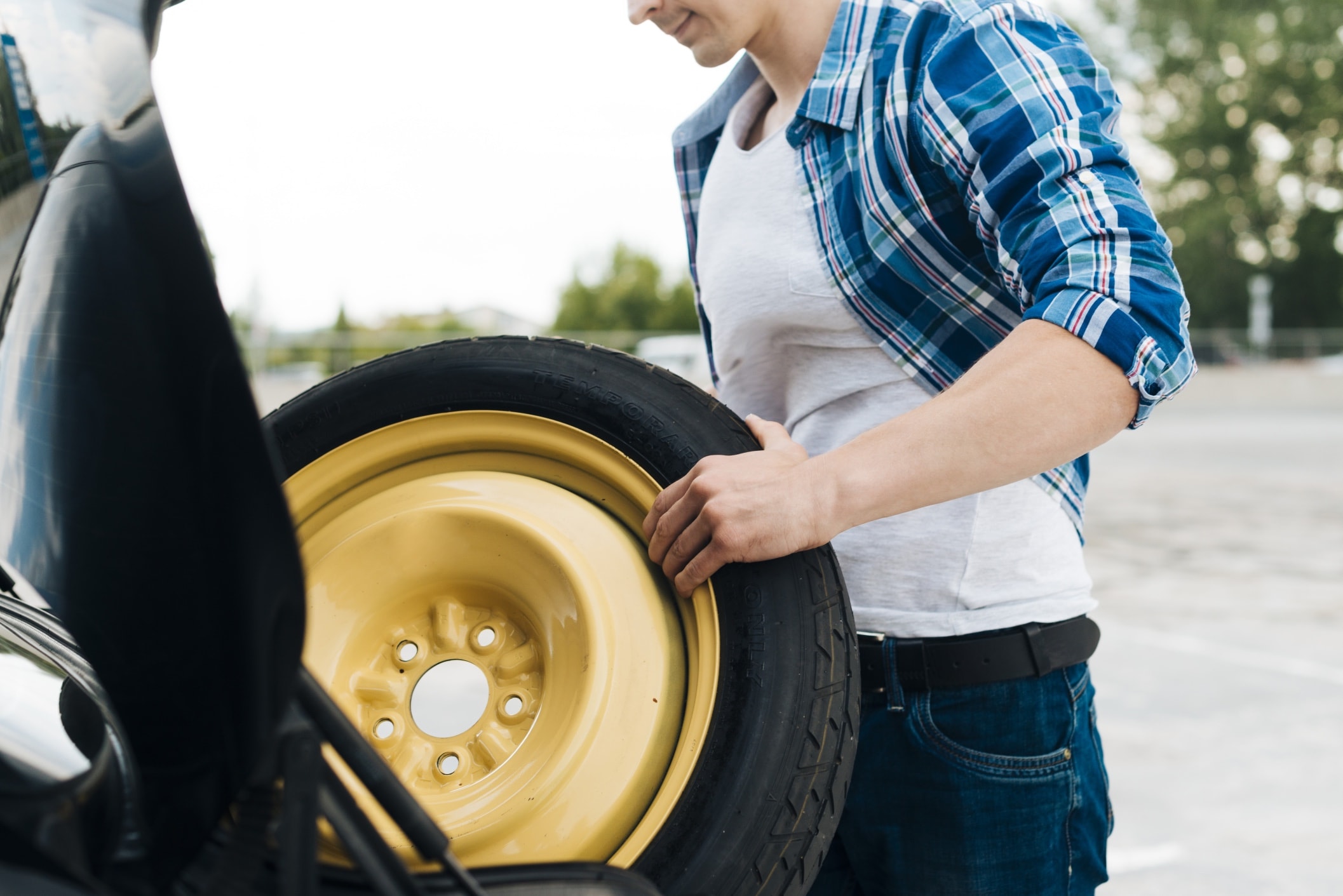 medium-shot-man-taking-out-spare-tire-2.jpg